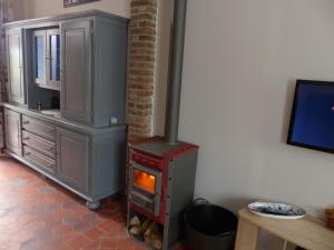 a woodburning stove in a kitchen with a table at maison floréal in Criel-sur-Mer