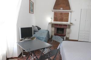 sala de estar con TV y chimenea en Casa Lungomare, en Giardini Naxos