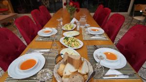 een lange houten tafel met borden eten erop bij Castle Nolana in Geredeli