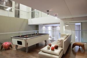 Una sala de estar con una mesa de billar y un sofá. en Esplendor by Wyndham Buenos Aires, en Buenos Aires