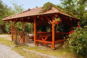 cenador de madera con mesa y flores en Expres Atack Penzion, en Brno