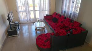 a living room with a red couch and a table at Sunile Villa in Flic-en-Flac