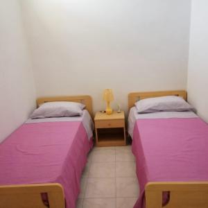 2 camas en una habitación con sábanas moradas en Casa del sole en Portopalo