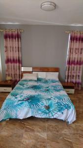 a bedroom with a bed with a blue comforter at Sunile Villa in Flic-en-Flac +17 photos