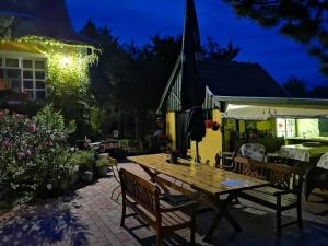 a wooden table in a patio at night at Villa-Magdi Vendégház in Révfülöp