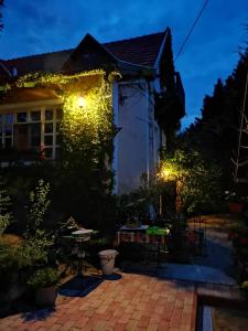 una casa iluminada por la noche con luces en Villa-Magdi Vendégház en Révfülöp