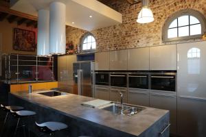 a kitchen with stainless steel appliances and a large island at Blue House On The Water in Kortrijk