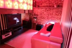 a living room with a red couch and a brick wall at Blue House On The Water in Kortrijk