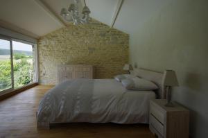 a bedroom with a bed and a large window at Le Clos Du Murier in Chassignelles +32 photos