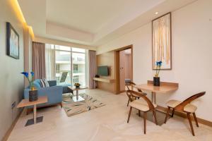 a living room with a couch and a table and chairs at Royal Central Hotel and Resort The Palm in Dubai