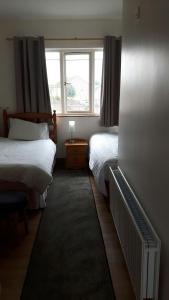 sypialnia z 2 łóżkami i oknem w obiekcie Scapaflow B&B w mieście OʼBriensbridge