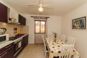 a kitchen with a table with chairs and a ceiling fan at Apartments Fedrigo in Sutivan