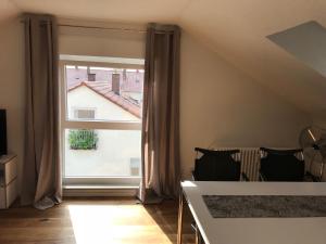 ラーベンスブルクにあるFerienwohnung *stadtnah* ruhig* modernの大きな窓とテーブルが備わる客室です。