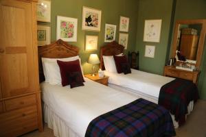 2 camas en una habitación con paredes verdes en The King Alfred Pub, en Winchester