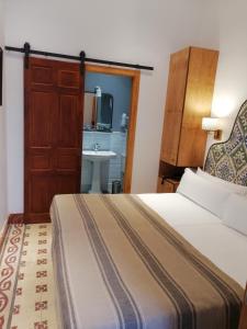 a hotel room with a bed and a sink at Santiago 15 Casa Palacio in Seville