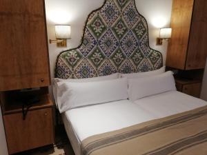 a bed with a large headboard in a room at Santiago 15 Casa Palacio in Seville