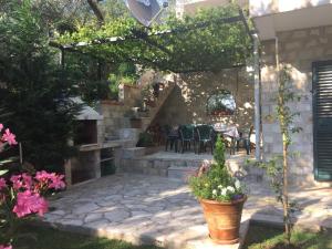 un patio con tavolo, sedie e fiori di Apartments Villa Lazic a Petrovac na Moru