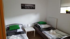 - 2 lits jumeaux dans une petite chambre avec une table dans l'établissement Niederdreisbacher Hütte - moderne Doppelzimmer - EINZELBETTEN -, à Niederdreisbach