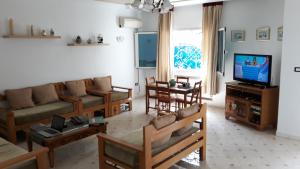 een woonkamer met meubilair en een flatscreen-tv bij Villa Bougainvillier in Sousse