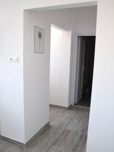 um quarto vazio com paredes brancas e pisos em madeira em Studio Eleven em Kisvárda