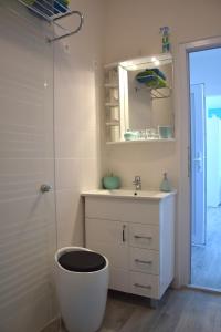 uma casa de banho com um WC, um lavatório e um espelho. em Studio Eleven em Kisvárda