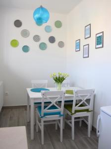 uma sala de jantar com uma mesa branca e 2 cadeiras em Studio Eleven em Kisvárda