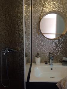 een badkamer met een wastafel en een spiegel bij Blue Beach Panorama in Révfülöp