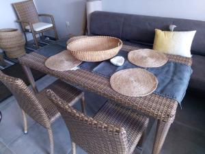 een tafel met rieten stoelen en een bank bij Blue Beach Panorama in Révfülöp +18 foto's