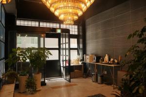 a lobby with plants and a large chandelier at SOYU Hotel in Busan