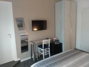 a bedroom with a desk and a bed and a tv at Acquasalata in Salerno