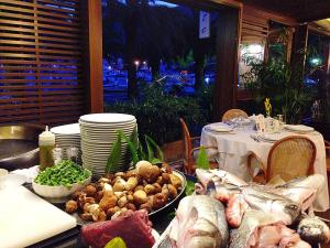 a table with meat and vegetables on a table at Hotel Della Baia in Portovenere