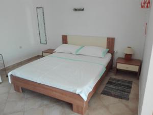 a bedroom with a large bed with white sheets and blue pillows at Cesarica Studio near sea in Cesarica