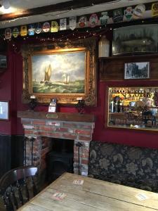 tiger inn في بريدبورت: موقد في مطعم به لوحات على الحائط