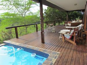 una terraza con bañera de hidromasaje, mesa y sillas en Nkumbe Bush Retreat Family Home en Ponta Malangane