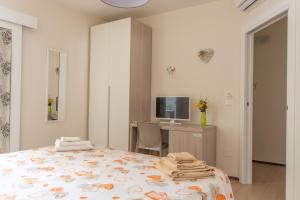 een slaapkamer met een bed, een bureau en een televisie bij Chiardiluna in Castro di Lecce