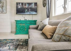 ein Wohnzimmer mit einem Sofa und einem TV in der Unterkunft Ez Living Apartments in Bridgetown