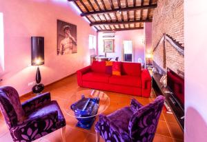 ein Wohnzimmer mit einem roten Sofa und Stühlen in der Unterkunft maison specchi in Rom
