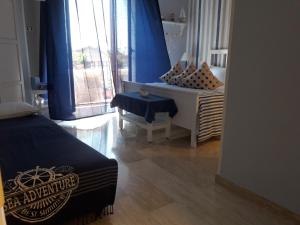 1 dormitorio con 1 cama con cortinas azules y ventana en B&B VelAmare, en Salerno