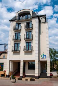 um edifício branco alto com janelas e varandas em D.N. Center em Międzyzdroje