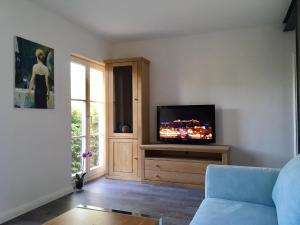 ein Wohnzimmer mit einem Flachbild-TV auf einem Schrank in der Unterkunft Ferienhaus Feel like Home Barbecue in Hamburg