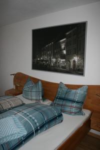 a bed with blue pillows and a picture on the wall at Apartment Rose in Todtmoos