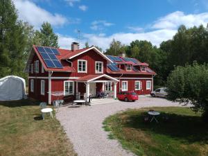 a red house with solar panels on the roof at Solmyra 56 Gästhem in Solmyra
