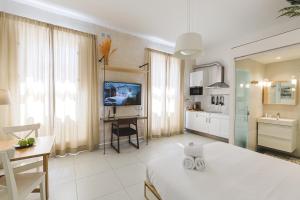 a large white room with a table and a kitchen at Two Pillows Boutique Hostel in Sliema