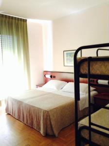 a bedroom with a bunk bed and a window at Hotel Du Parc in Atri