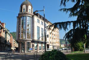 un edificio con una torre de reloj en una calle de la ciudad en Hotel Mieres del Camino, en Mieres