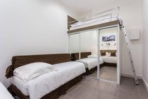 sypialnia z łóżkiem piętrowym i lustrem w obiekcie Le Logis de Montmartre w Paryżu