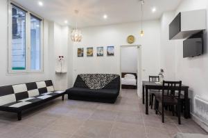 a living room with a couch and a table at Le Logis de Montmartre in Paris