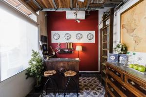 une chambre avec un mur rouge et deux tabourets dans l'établissement Two Pillows Boutique Hostel, à Sliema