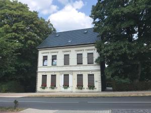 a white building with a black roof and windows at Ferienwohnung Wieneke in Velbert