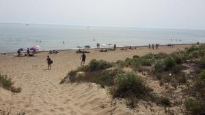 a group of people on a beach with the ocean at Villa Salvatore in San Leone